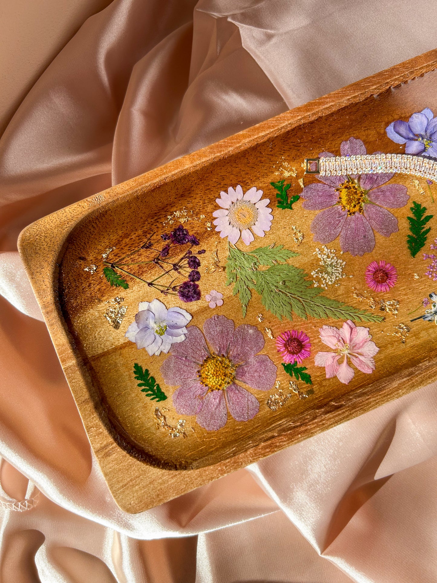 A beautiful decorative wood and resin tray with real natural dried flowers in a colorful pink, purple, green, white, yellow, and blue arrangement. size is 35 cm × 14 cm, approximately 13.78 inches × 5.51 inches. It is a beautiful thoughtful gift for a loved one and decorates every space effortlessly.