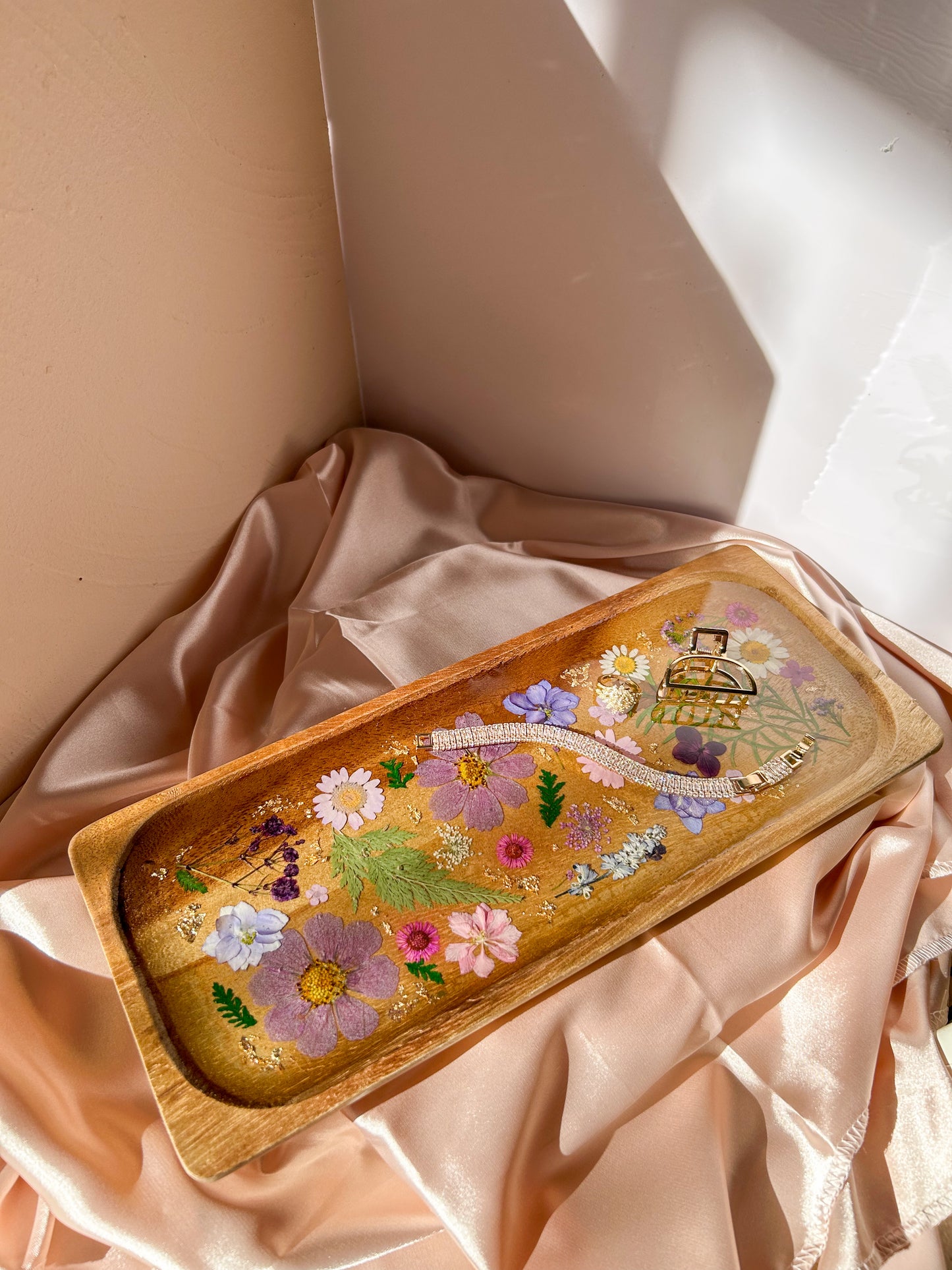 A beautiful decorative wood and resin tray with real natural dried flowers in a colorful pink, purple, green, white, yellow, and blue arrangement. size is 35 cm × 14 cm, approximately 13.78 inches × 5.51 inches. It is a beautiful thoughtful gift for a loved one and decorates every space effortlessly.