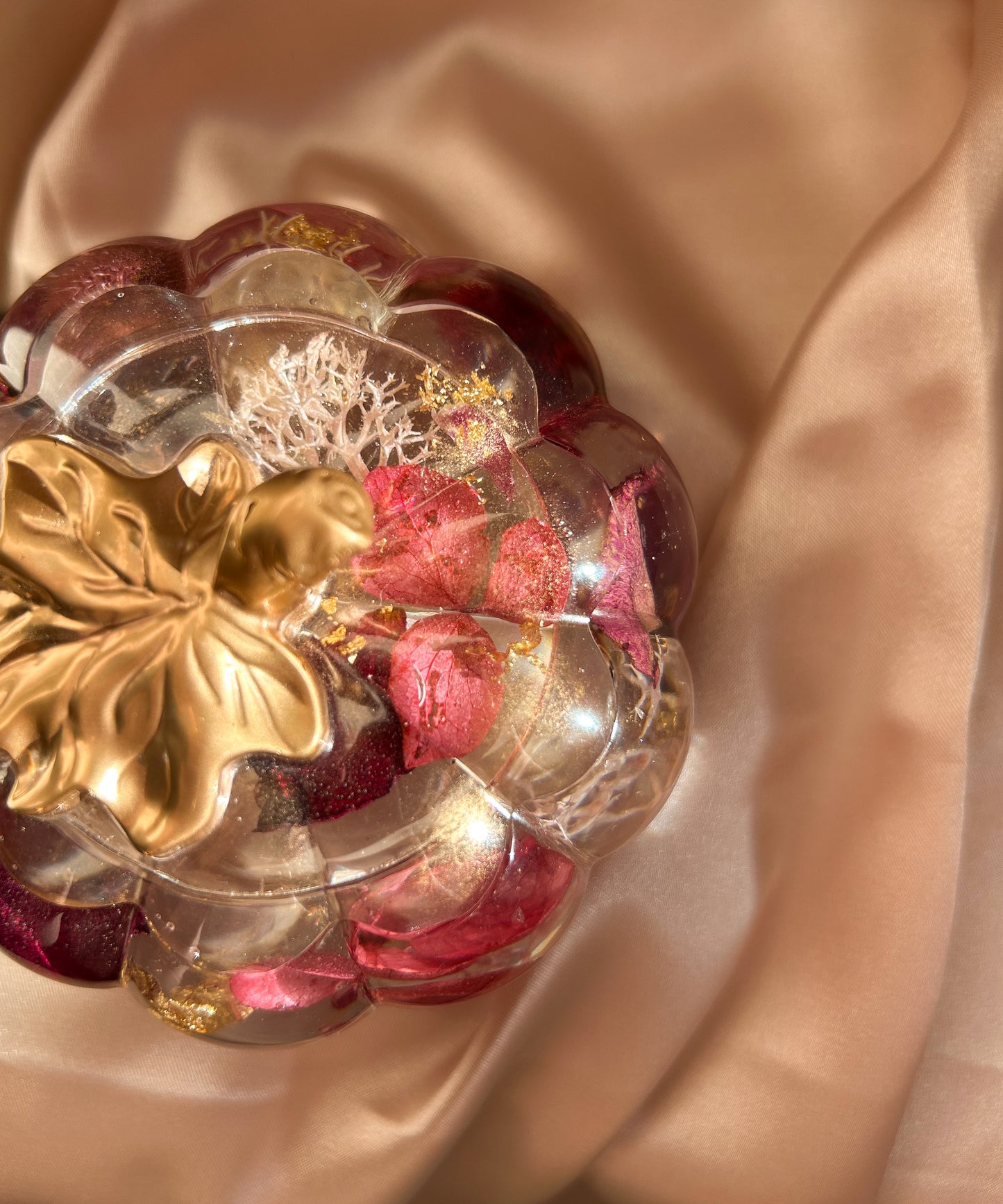 A handmade floral pumpkin-shaped resin jewelry jar with real dried flowers embedded inside. The jar has a smooth, glossy finish and is designed for storing rings, earrings, necklaces, and other small jewelry. Its elegant nature-inspired design makes it a unique decorative piece, perfect for boho or cottagecore home decor.