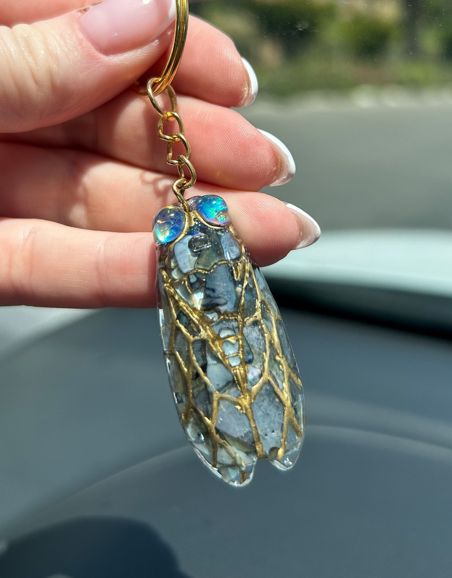 Handmade cicada keychain crafted with resin, real black abalone shell, glitter, and hand-painted ink, featuring a unique insect design, perfect for nature and bug lovers.