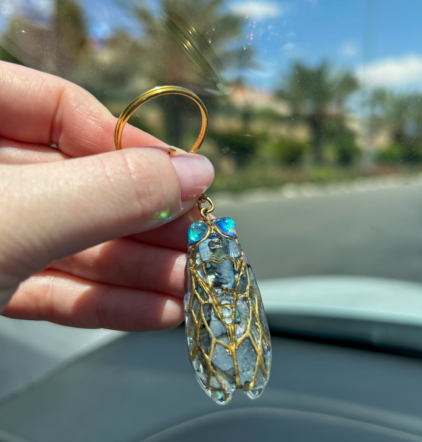 Handmade cicada keychain crafted with resin, real black abalone shell, glitter, and hand-painted ink, featuring a unique insect design, perfect for nature and bug lovers.