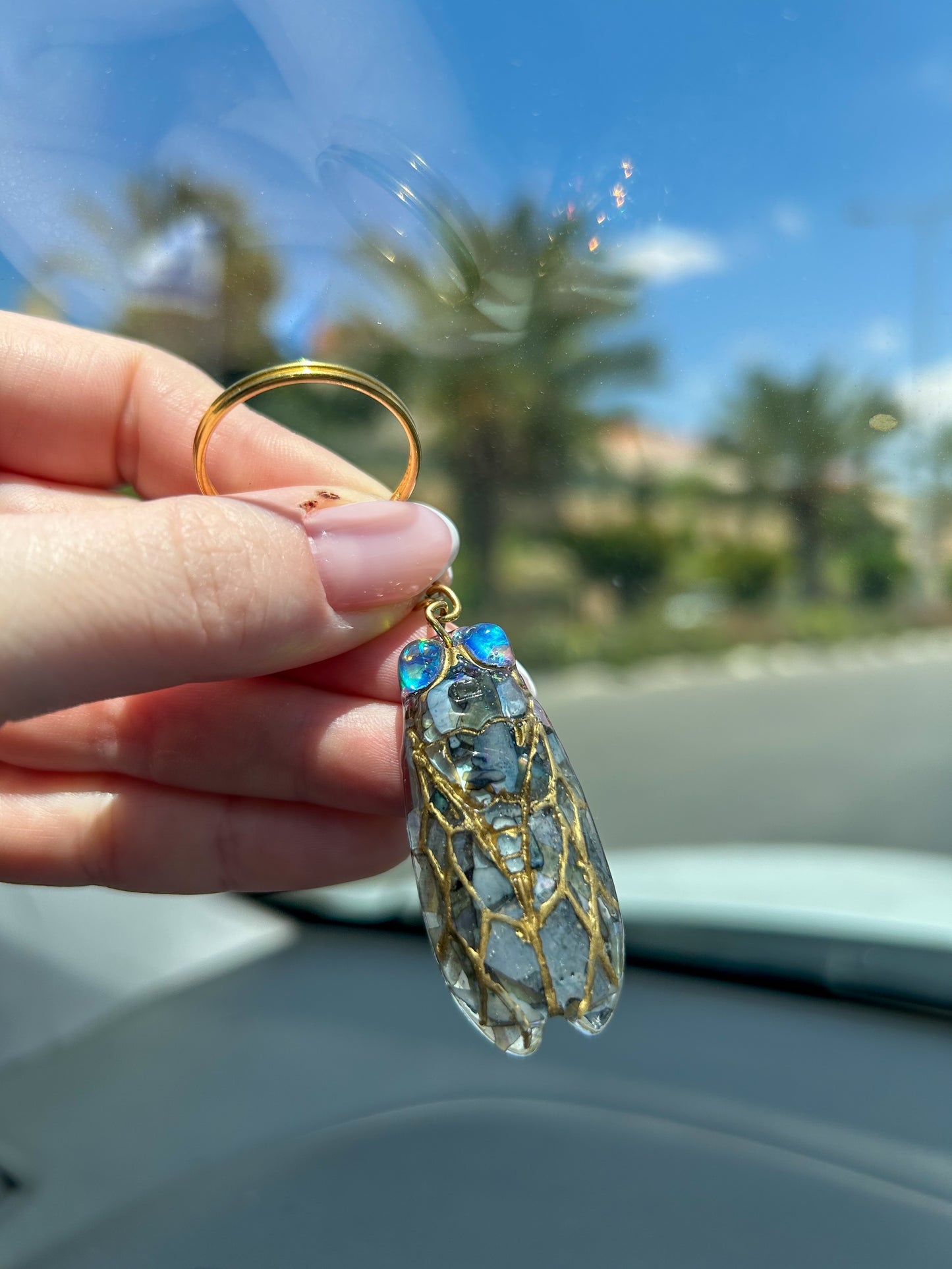 Handmade cicada keychain crafted with resin, real black abalone shell, glitter, and hand-painted ink, featuring a unique insect design, perfect for nature and bug lovers.