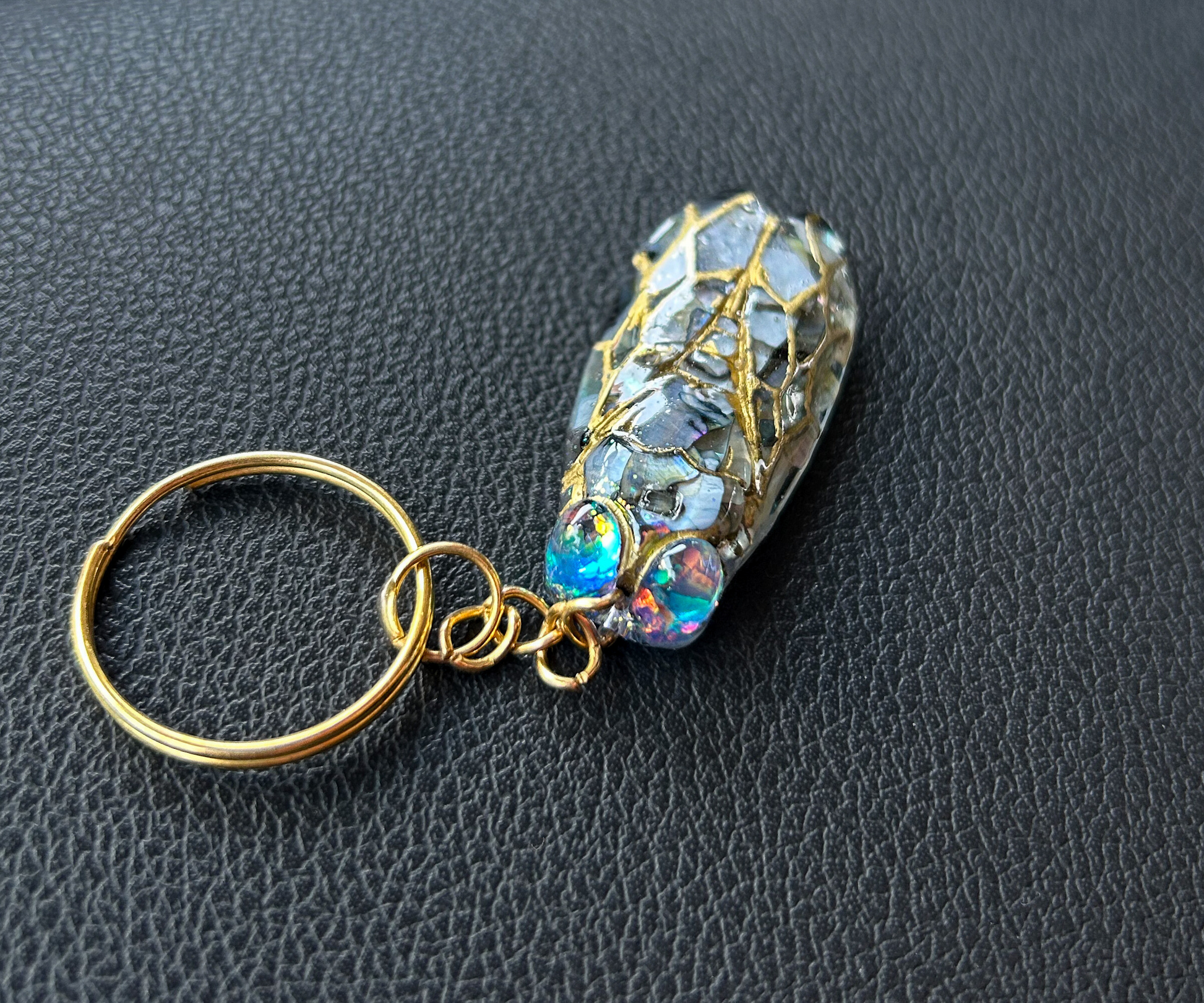 Handmade cicada keychain crafted with resin, real black abalone shell, glitter, and hand-painted ink, featuring a unique insect design, perfect for nature and bug lovers.