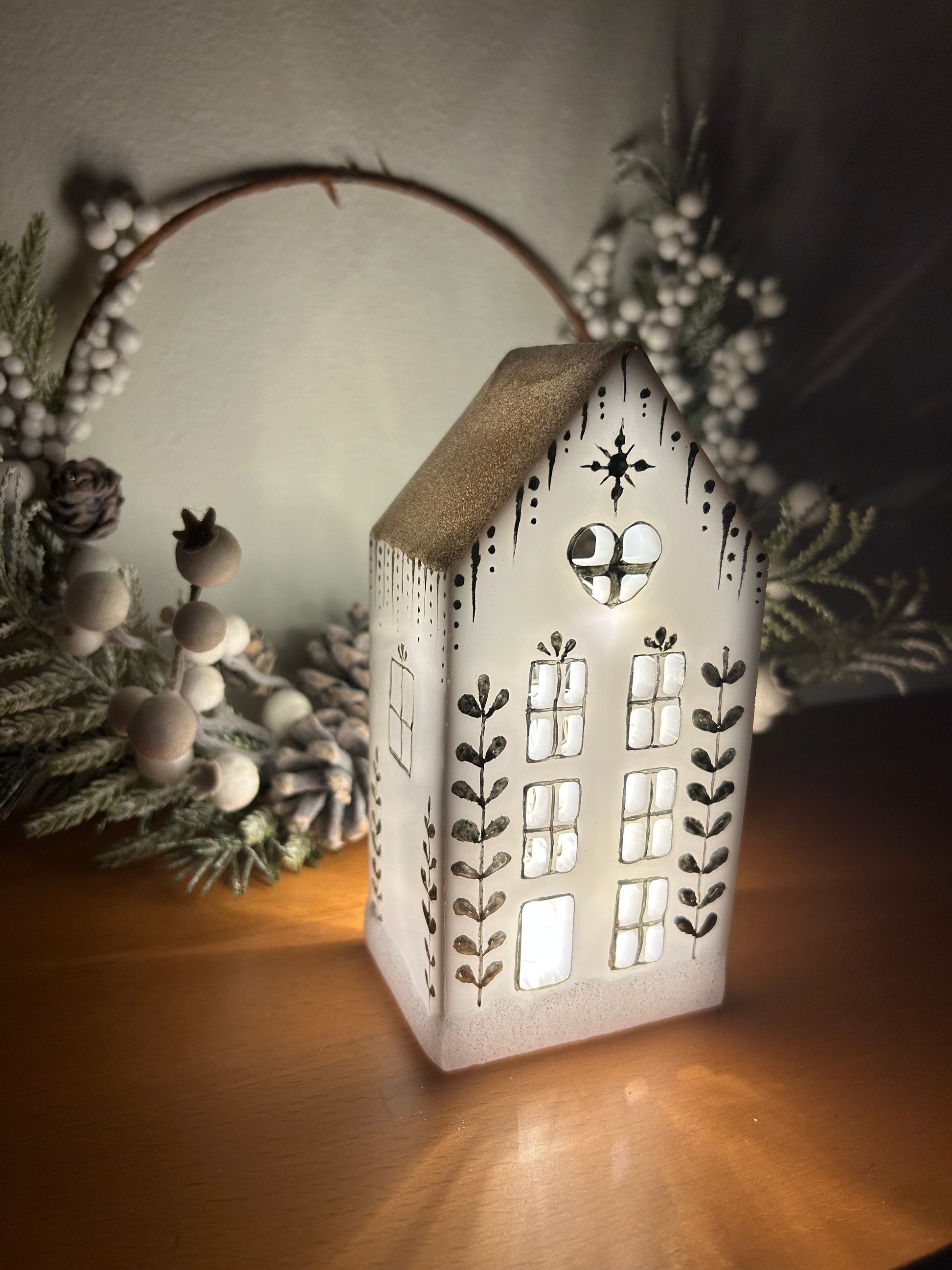 A beautiful handmade white resin gingerbread christmas tree house candle holder with golden decorations and a golden sparkly rooftop