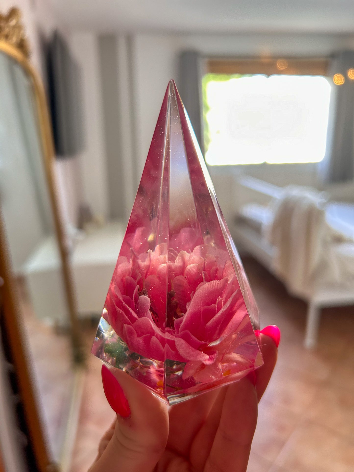 Handmade pink flower resin ring tree with real flowers encased in glossy resin. This jewelry holder is perfect for organizing rings and small accessories. Soft pink tones add a delicate touch, making it an ideal decorative piece or gift.