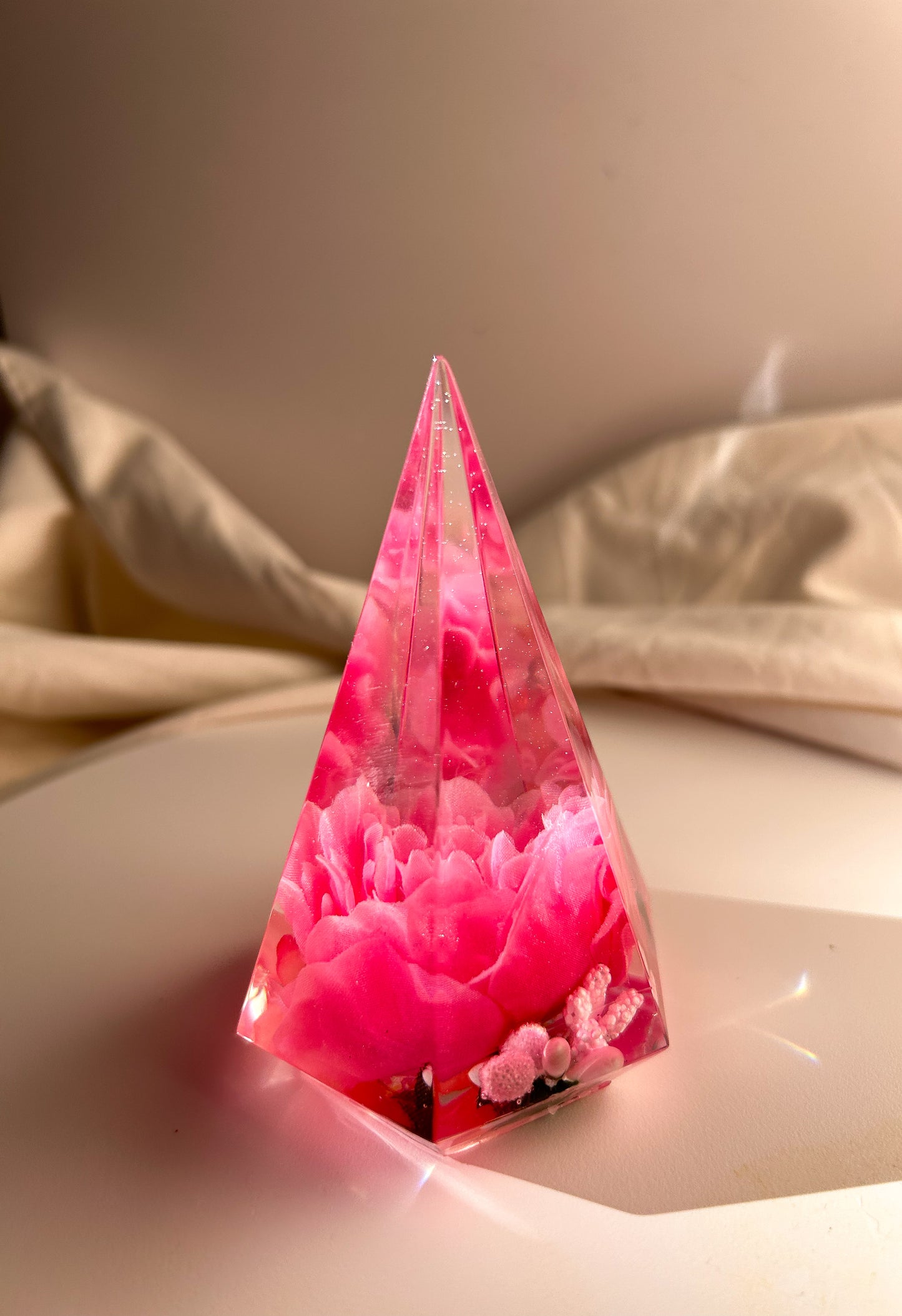 Handmade pink flower resin ring tree with real flowers encased in glossy resin. This jewelry holder is perfect for organizing rings and small accessories. Soft pink tones add a delicate touch, making it an ideal decorative piece or gift.