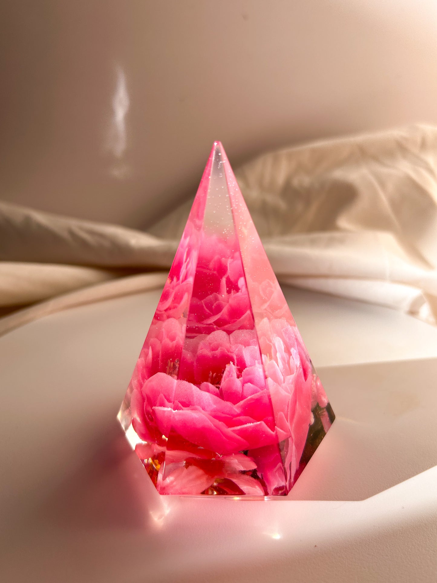 Handmade pink flower resin ring tree with real flowers encased in glossy resin. This jewelry holder is perfect for organizing rings and small accessories. Soft pink tones add a delicate touch, making it an ideal decorative piece or gift.