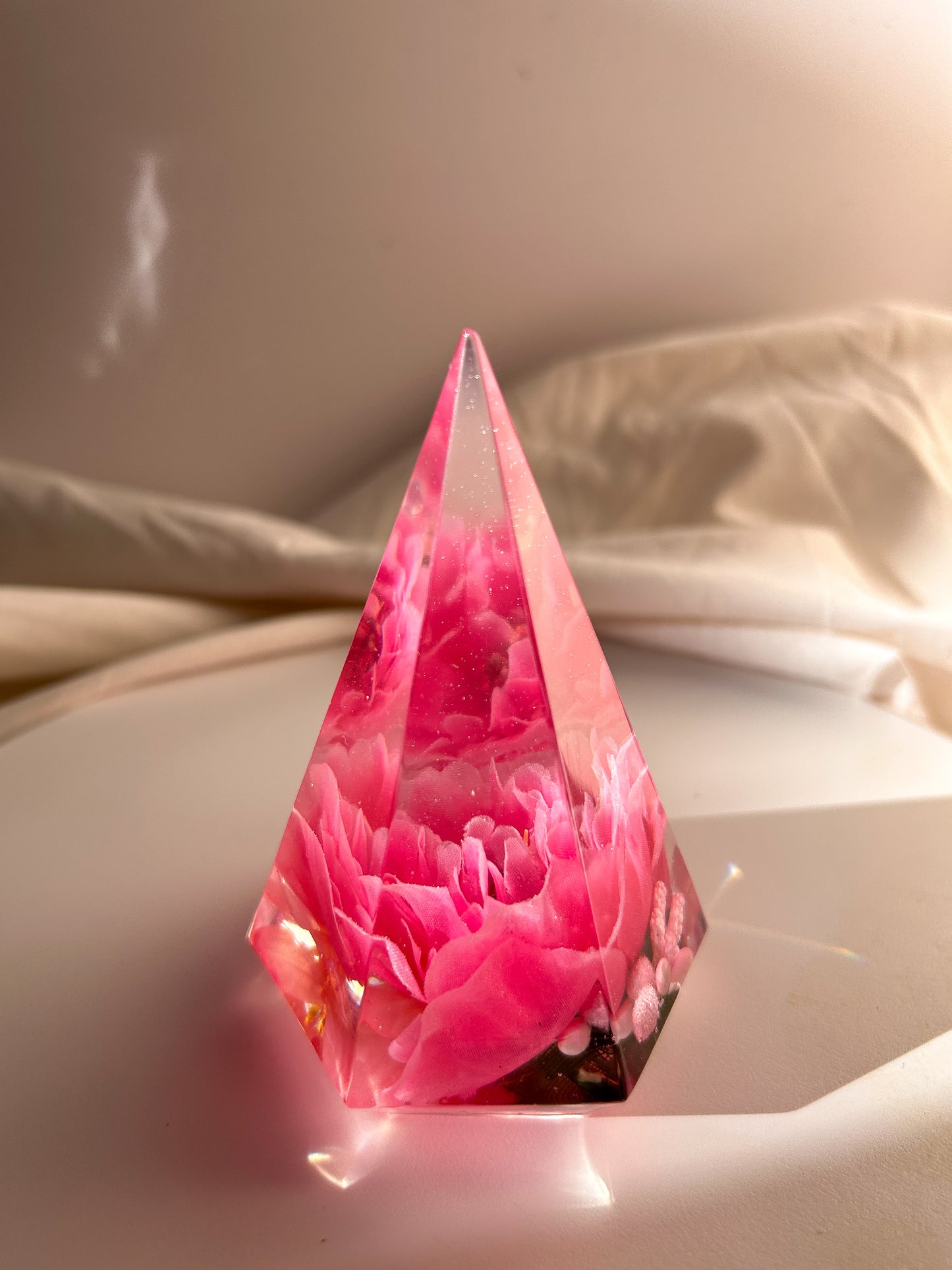 Handmade pink flower resin ring tree with real flowers encased in glossy resin. This jewelry holder is perfect for organizing rings and small accessories. Soft pink tones add a delicate touch, making it an ideal decorative piece or gift.