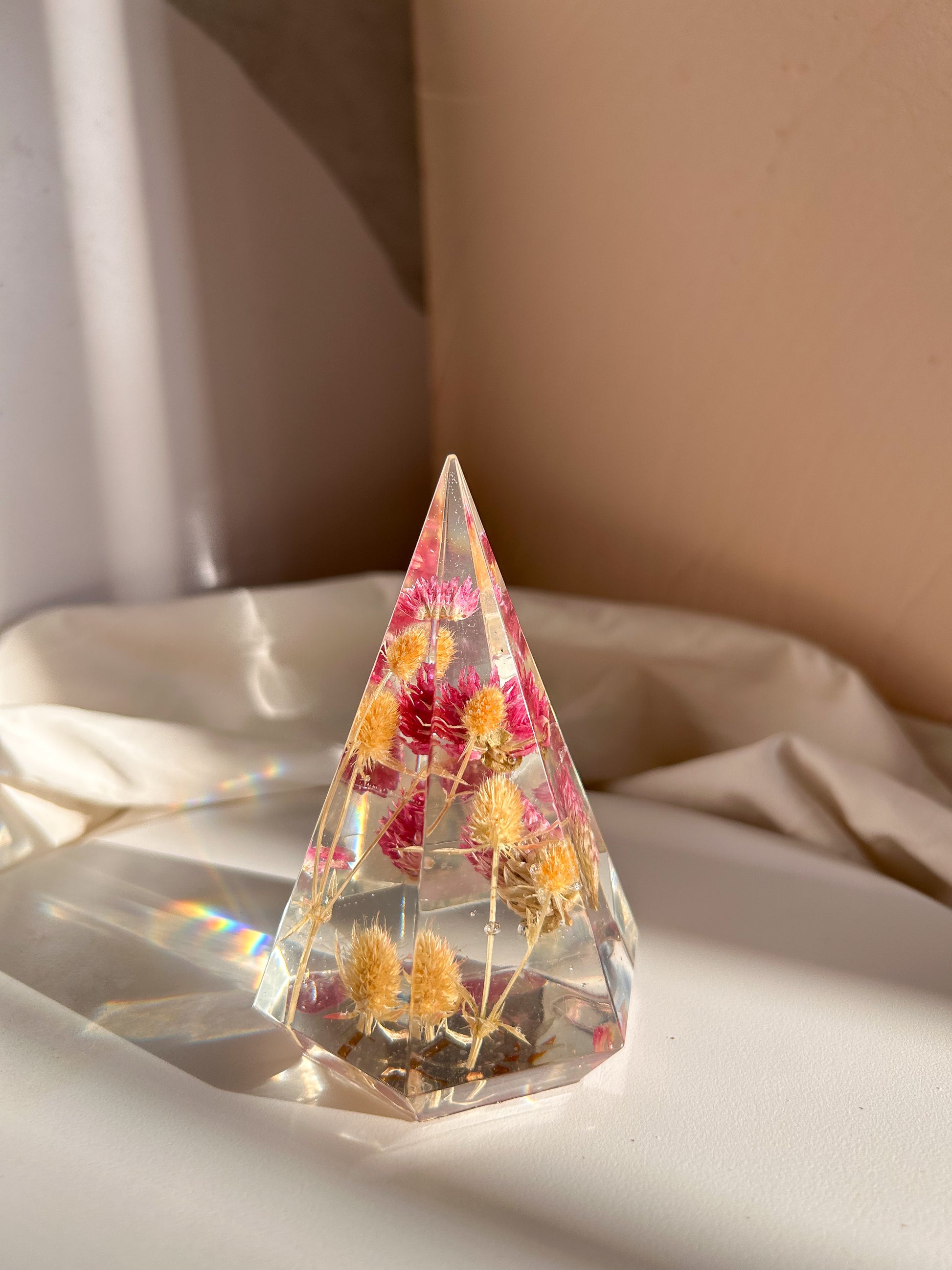 a handmade resin ring tree ring cone featuring floral dried botanicals, a dried desert beige thorn with vibrant fuchsia pink spiky flower. perfect for displaying rings, a unique botanical gift. beautiful, bedroom, bathroom, office, nightstand decor