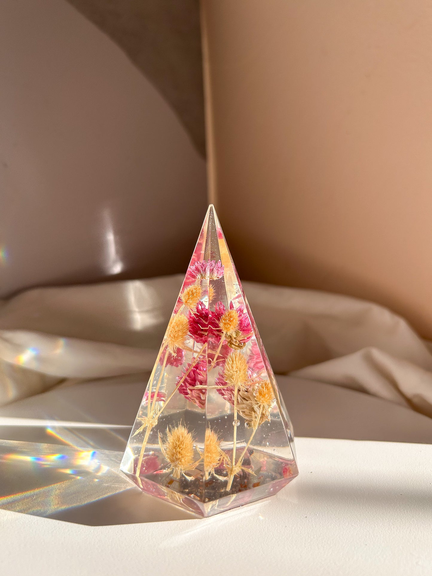 a handmade resin ring tree ring cone featuring floral dried botanicals, a dried desert beige thorn with vibrant fuchsia pink spiky flower. perfect for displaying rings, a unique botanical gift. beautiful, bedroom, bathroom, office, nightstand decor