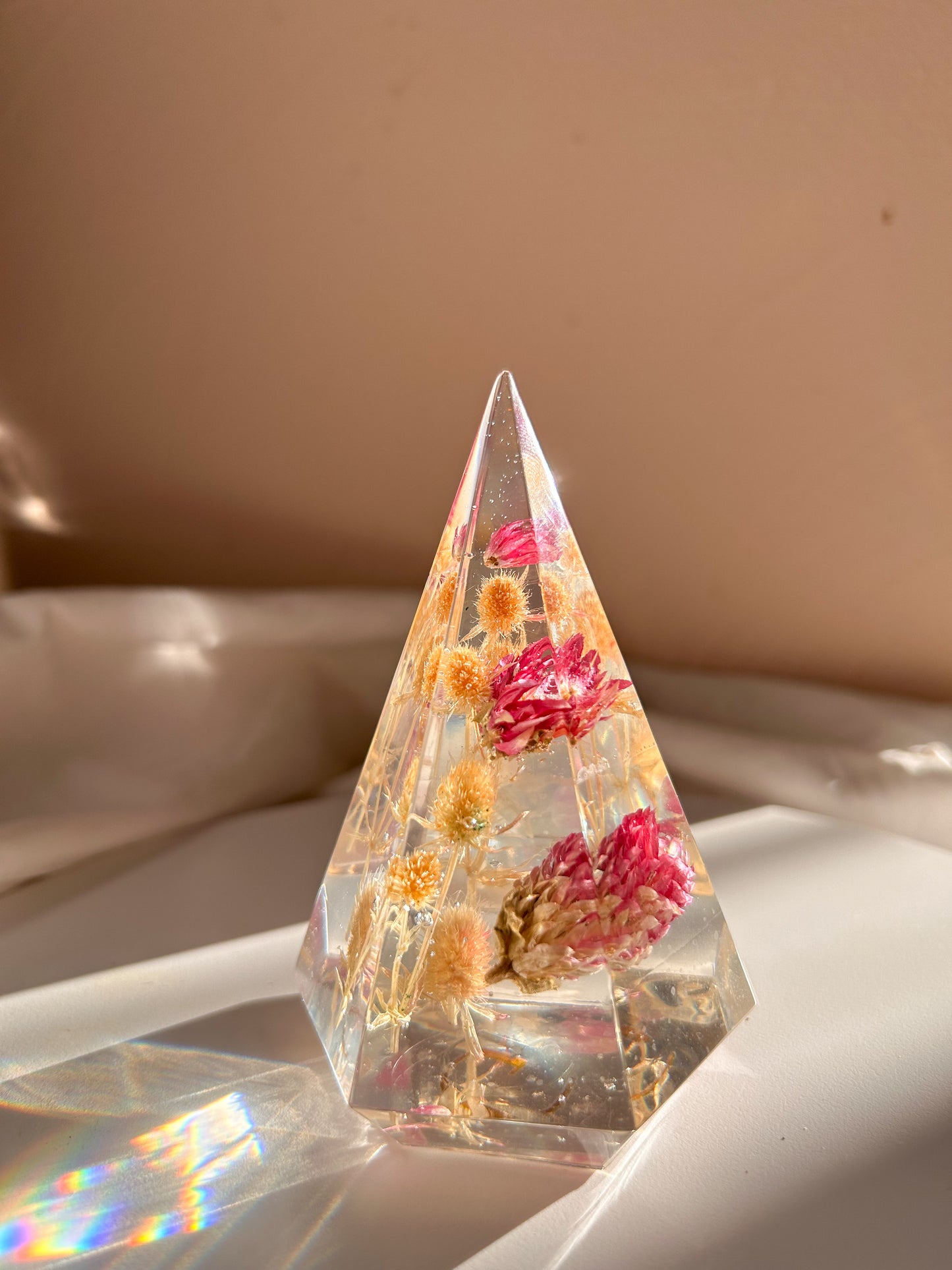 a handmade resin ring tree ring cone featuring floral dried botanicals, a dried desert beige thorn with vibrant fuchsia pink spiky flower. perfect for displaying rings, a unique botanical gift. beautiful, bedroom, bathroom, office, nightstand decor