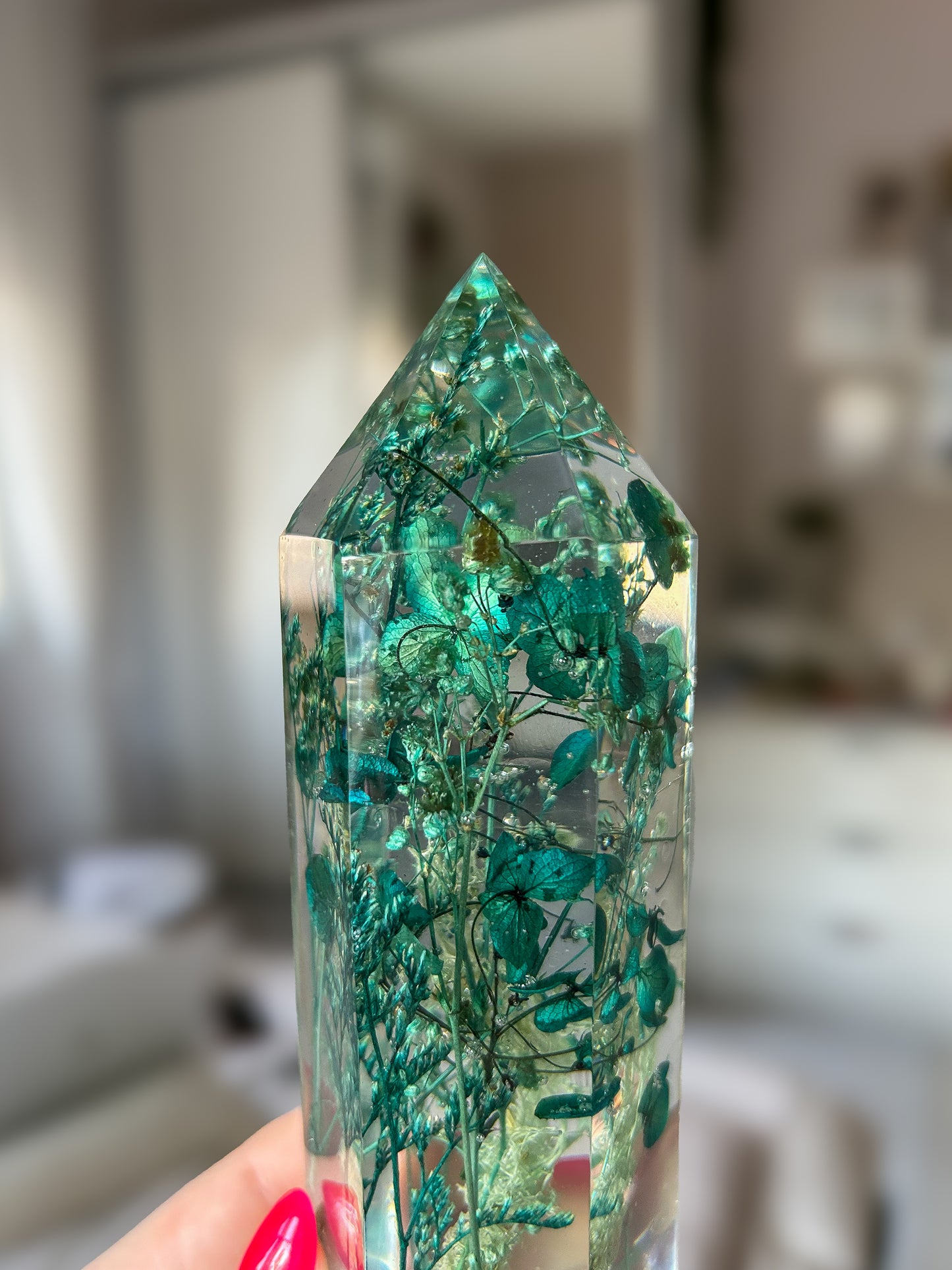 A beautiful handmade epoxy resin crystal made with blue teal, light blue and green natural dried flowers. perfectly cast in crystal clear epoxy resin. Great for home decor, gifts, unique presents, vanity bedroom decor and shelf decor.