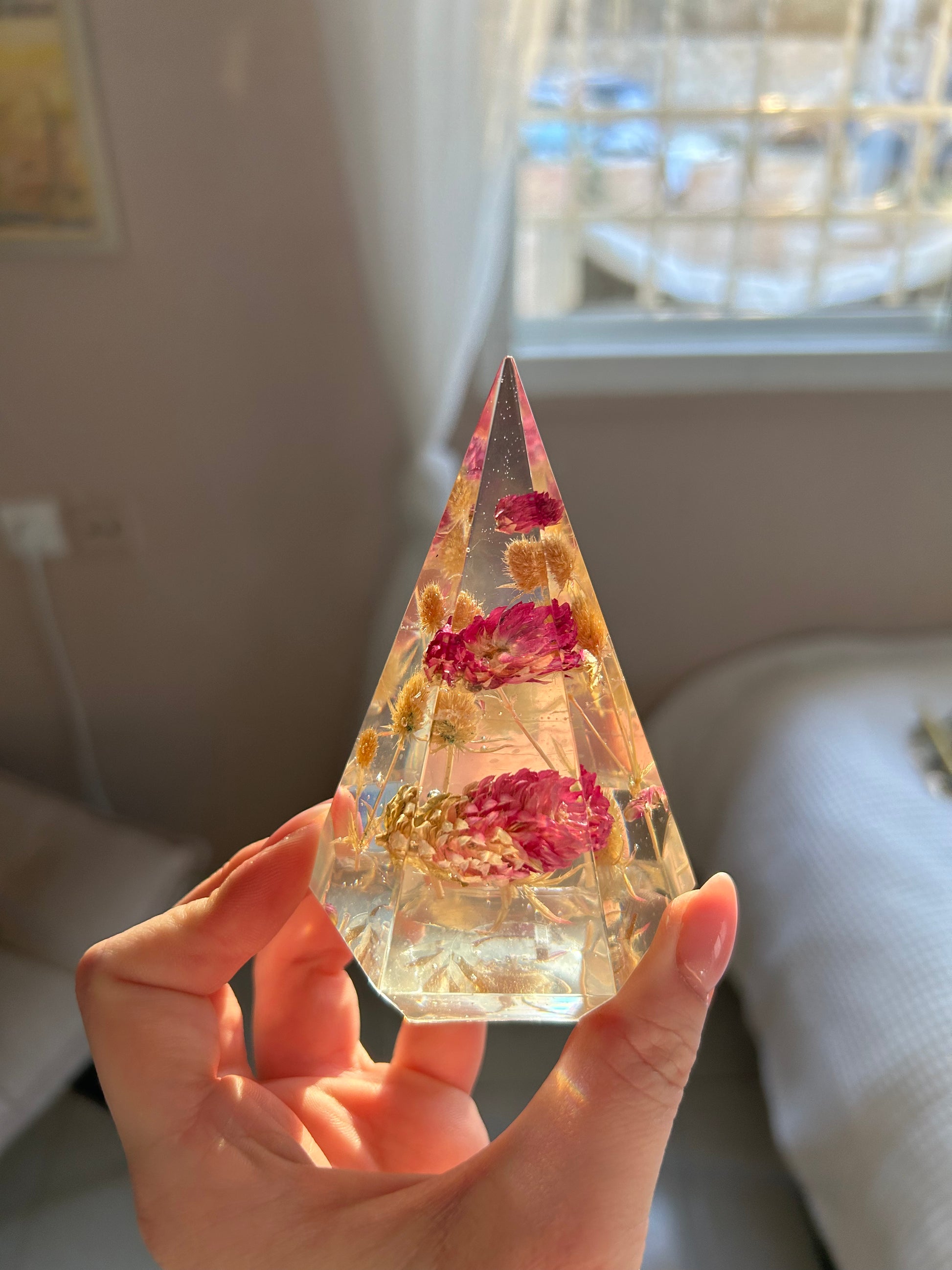 a handmade resin ring tree ring cone featuring floral dried botanicals, a dried desert beige thorn with vibrant fuchsia pink spiky flower. perfect for displaying rings, a unique botanical gift. beautiful, bedroom, bathroom, office, nightstand decor