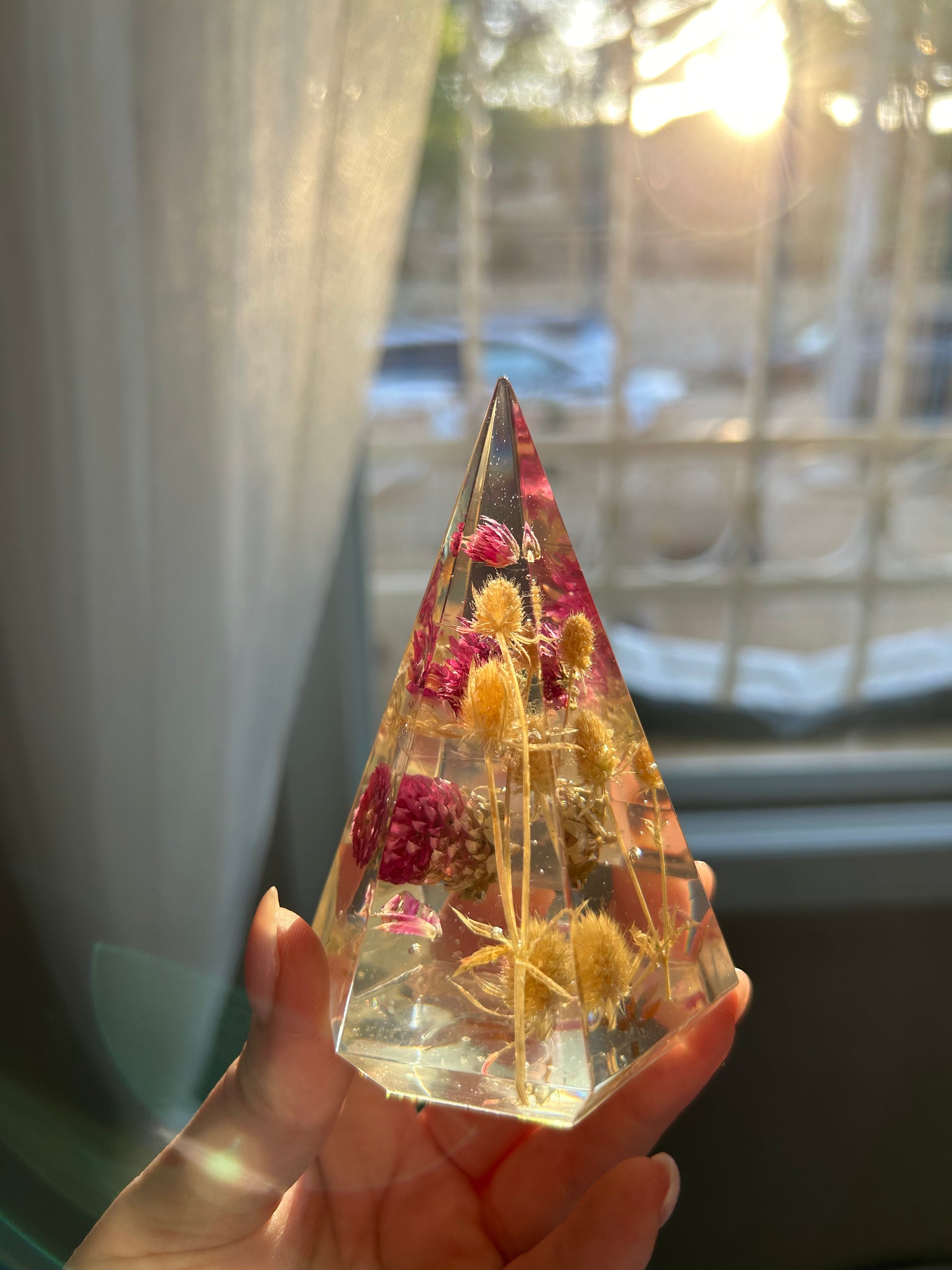 a handmade resin ring tree ring cone featuring floral dried botanicals, a dried desert beige thorn with vibrant fuchsia pink spiky flower. perfect for displaying rings, a unique botanical gift. beautiful, bedroom, bathroom, office, nightstand decor