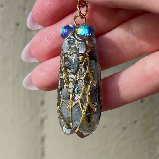 Handmade cicada keychain crafted with resin, real black abalone shell, glitter, and hand-painted ink, featuring a unique insect design, perfect for nature and bug lovers.