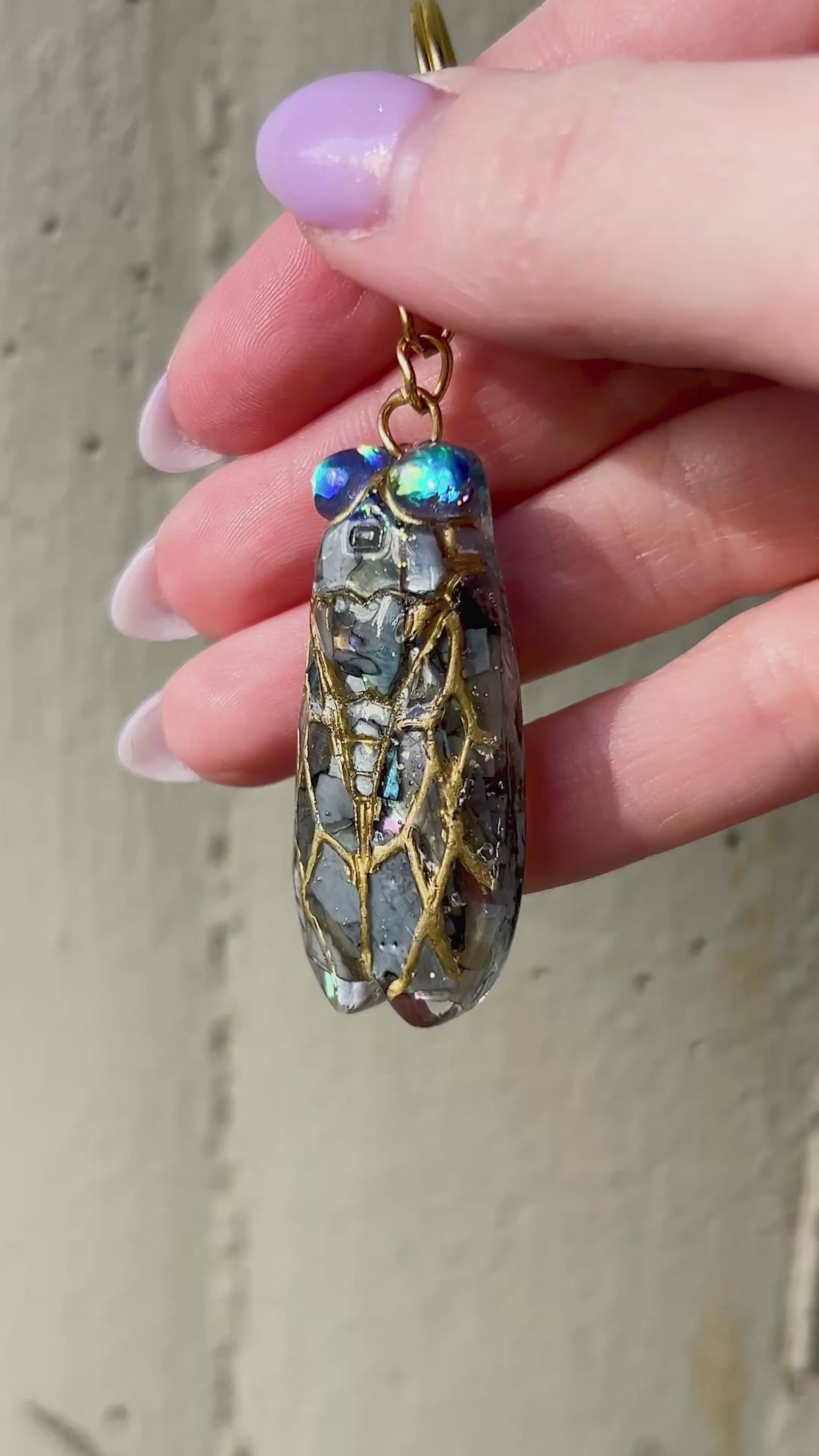 Handmade cicada keychain crafted with resin, real black abalone shell, glitter, and hand-painted ink, featuring a unique insect design, perfect for nature and bug lovers.