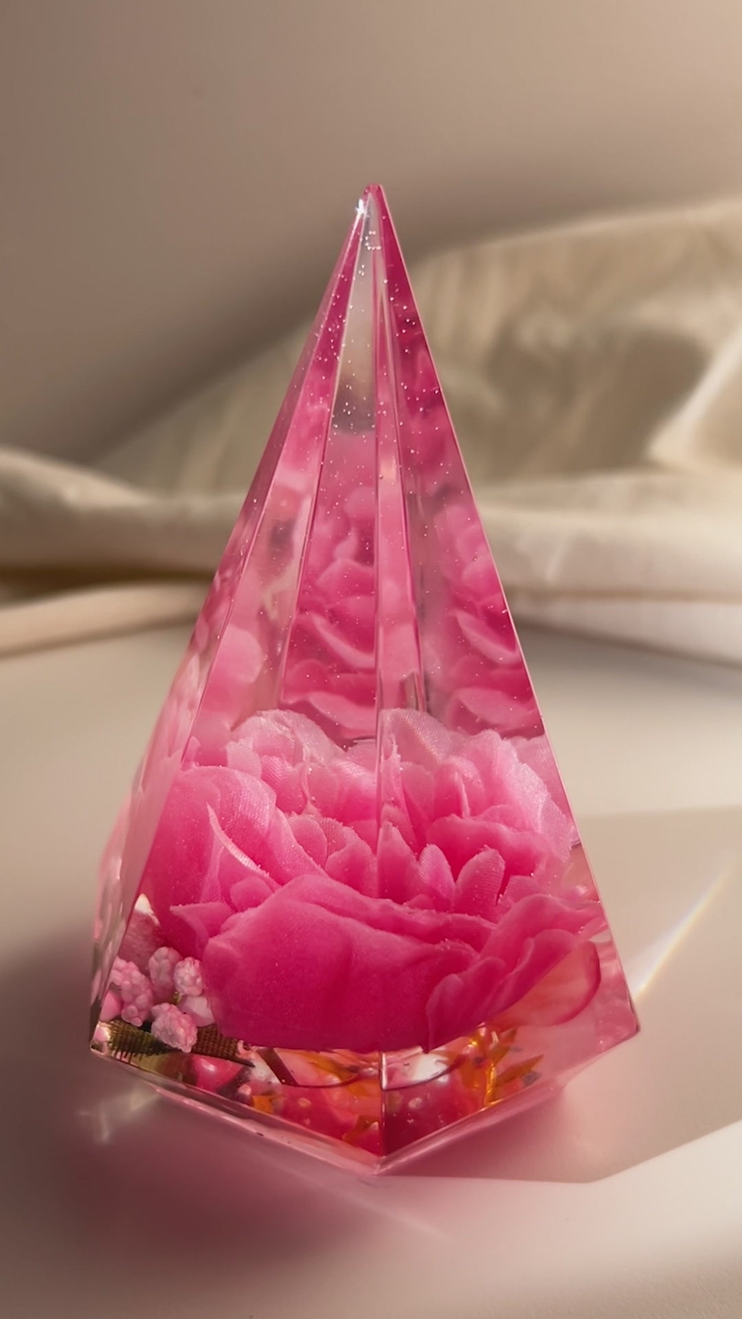 Handmade pink flower resin ring tree with real flowers encased in glossy resin. This jewelry holder is perfect for organizing rings and small accessories. Soft pink tones add a delicate touch, making it an ideal decorative piece or gift.